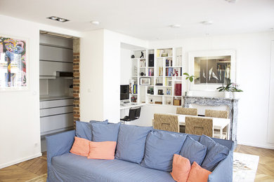Cette photo montre un salon tendance ouvert avec un mur blanc, parquet clair et une cheminée standard.