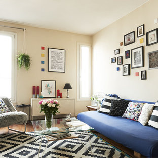 Réalisation d'un salon bohème avec un mur beige, un sol en bois foncé et un sol marron.