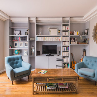 Idée de décoration pour un salon avec une bibliothèque ou un coin lecture tradition fermé avec un mur gris, un sol en bois brun, un téléviseur indépendant et aucune cheminée.