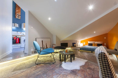 Réalisation d'un salon design ouvert avec tomettes au sol, un bar de salon, un mur orange et un téléviseur indépendant.