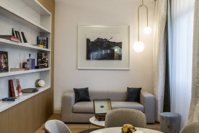 Свежая идея для дизайна: изолированная гостиная комната среднего размера в современном стиле с с книжными шкафами и полками, белыми стенами и светлым паркетным полом без телевизора - отличное фото интерьера