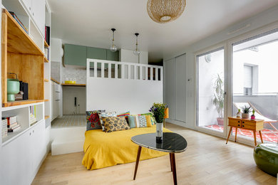 Inspiration pour un salon nordique de taille moyenne et ouvert avec un mur vert et parquet clair.