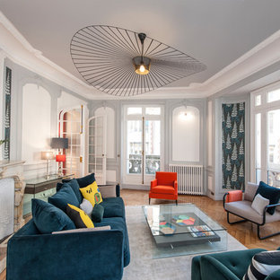 Réalisation d'un grand salon design fermé et haussmannien avec une salle de réception, un mur multicolore, un sol en bois brun et une cheminée standard.