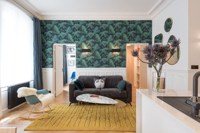 Exemple d'un salon tendance ouvert avec un mur vert et parquet clair.