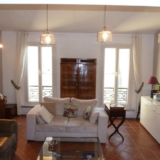 Mediterranes Wohnzimmer mit weißer Wandfarbe, Terrakottaboden und orangem Boden in Sonstige