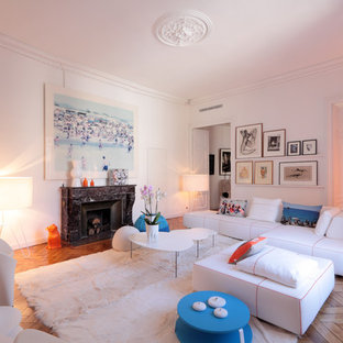 Cette photo montre un salon tendance de taille moyenne et ouvert avec un mur blanc, un sol en bois clair et une cheminée standard.