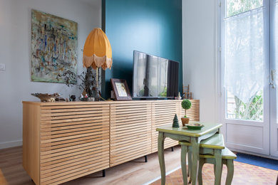 Idée de décoration pour un salon design avec un mur vert, parquet clair et un téléviseur indépendant.