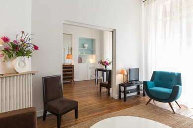 Diseño de salón abierto nórdico de tamaño medio sin chimenea con paredes blancas, suelo de madera clara, suelo marrón y televisor independiente