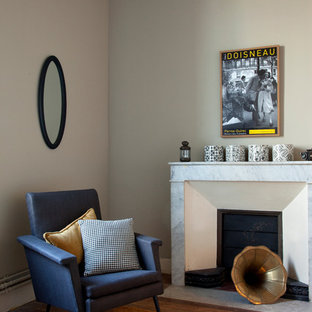 Cette image montre un salon vintage de taille moyenne et ouvert avec un mur beige, un sol en bois brun, une cheminée standard, un manteau de cheminée en pierre et aucun téléviseur.