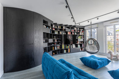 Aménagement d'un grand salon contemporain ouvert avec une bibliothèque ou un coin lecture, un mur noir, parquet foncé, aucune cheminée, un téléviseur encastré et un sol gris.