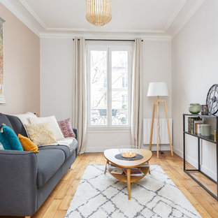 Idée de décoration pour un salon nordique avec un mur blanc, un sol en bois clair, aucune cheminée, aucun téléviseur et un sol beige.