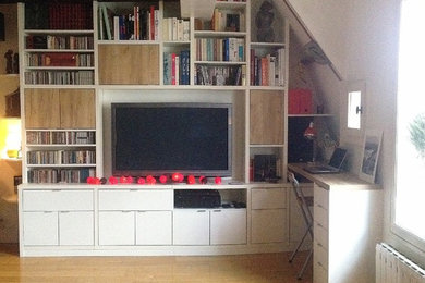 На фото: открытая гостиная комната среднего размера в классическом стиле с с книжными шкафами и полками, белыми стенами, светлым паркетным полом и телевизором на стене
