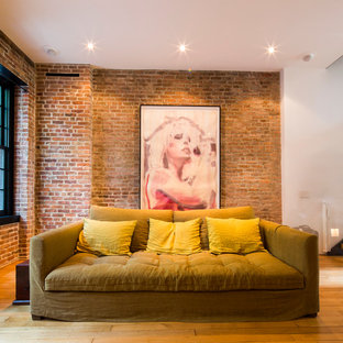 Cette image montre un grand salon design ouvert avec une salle de réception, un mur rouge, un sol en bois clair, aucune cheminée et aucun téléviseur.