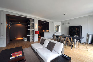 Cette photo montre un grand salon moderne ouvert avec un bar de salon, un mur blanc, parquet clair, aucune cheminée et un sol beige.