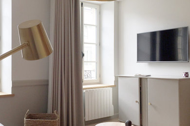 Réalisation d'un petit salon tradition ouvert avec un mur beige, parquet clair et un téléviseur fixé au mur.