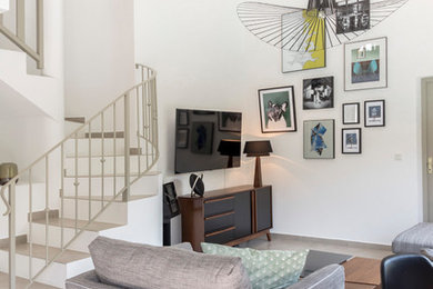 Immagine di un soggiorno scandinavo di medie dimensioni con pareti bianche e TV a parete