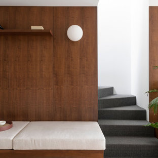 Immagine di una scala a "L" nordica di medie dimensioni con pedata in moquette, alzata in moquette, parapetto in metallo e boiserie