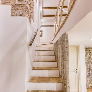 Esempio di una scala a rampa dritta country di medie dimensioni con pedata in terracotta e parapetto in legno
