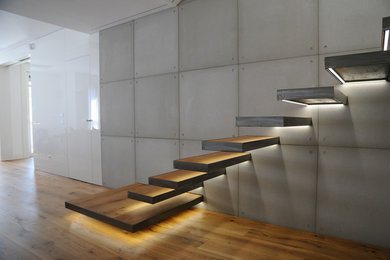Imagen de escalera en L actual de tamaño medio sin contrahuella con escalones de madera