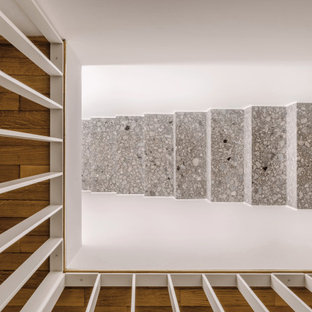 Idee per una grande scala a rampa dritta design con pedata in pietra calcarea, alzata in pietra calcarea e parapetto in metallo