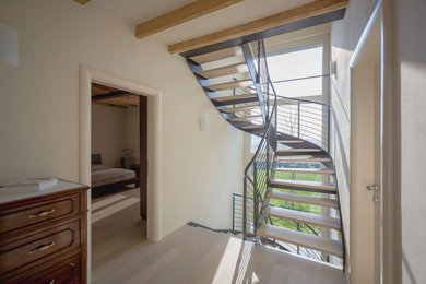 Inspiration for a contemporary wood curved staircase in Milan with open risers.