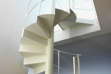 Foto di una scala a chiocciola minimalista con pedata in metallo e alzata in metallo