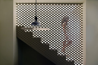 Foto de escalera en L contemporánea de tamaño medio con escalones con baldosas, contrahuellas con baldosas y/o azulejos y barandilla de metal