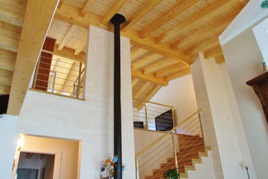 Imagen de escalera en L grande con escalones de madera, contrahuellas de madera y barandilla de metal