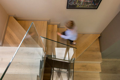 Imagen de escalera en U actual grande con escalones de madera y contrahuellas de madera