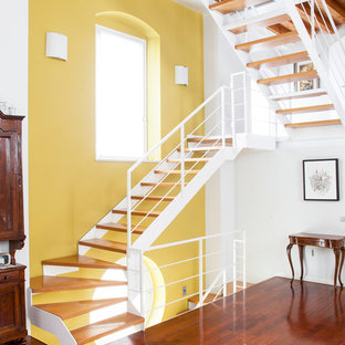 Cette photo montre un grand escalier sans contremarche méditerranéen en U avec des marches en bois et un garde-corps en métal.