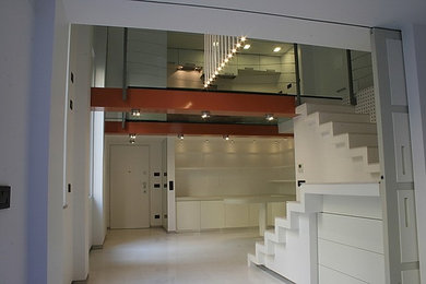 Foto di una scala a "U" minimal di medie dimensioni con pedata in marmo, alzata in marmo e parapetto in metallo