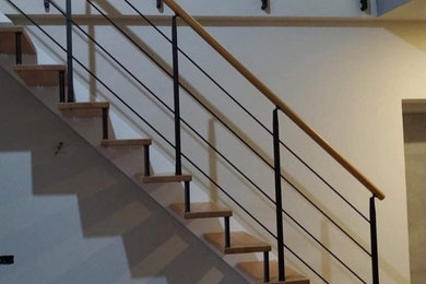 Imagen de escalera recta moderna de tamaño medio sin contrahuella con escalones de madera y barandilla de varios materiales