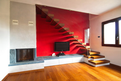 Imagen de escalera en L moderna de tamaño medio sin contrahuella con escalones de madera y barandilla de vidrio