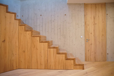 他の地域にある広いコンテンポラリースタイルのおしゃれな直階段 (木の蹴込み板) の写真
