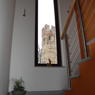 Esempio di una grande scala contemporanea con pedata in pietra calcarea, alzata in pietra calcarea e parapetto in metallo