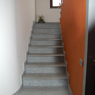 Immagine di una grande scala design con pedata in pietra calcarea, alzata in pietra calcarea e parapetto in metallo