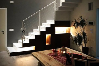 Diseño de escalera en L moderna de tamaño medio con escalones de metal, contrahuellas de metal y barandilla de metal