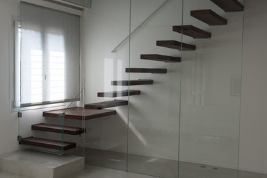 Ejemplo de escalera suspendida actual de tamaño medio con escalones de madera pintada