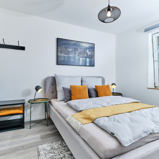 Modernes Schlafzimmer mit weißer Wandfarbe, hellem Holzboden und grauem Boden in Hamburg