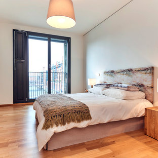 Modernes Gästezimmer ohne Kamin mit weißer Wandfarbe, braunem Holzboden und braunem Boden in Hamburg