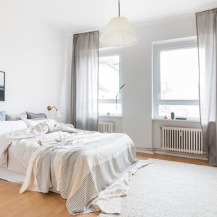 Mittelgroßes Skandinavisches Hauptschlafzimmer ohne Kamin mit weißer Wandfarbe, Laminat und beigem Boden in Berlin