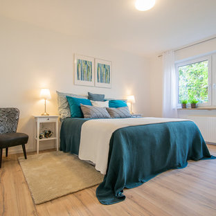 Klassisches Schlafzimmer mit weißer Wandfarbe, braunem Holzboden und braunem Boden in München