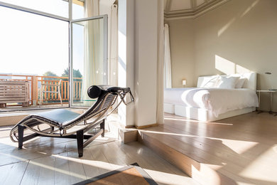 На фото: хозяйская спальня в стиле фьюжн с светлым паркетным полом с