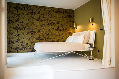 Kleines Stilmix Schlafzimmer im Loft-Style mit grüner Wandfarbe, gebeiztem Holzboden und weißem Boden in Berlin