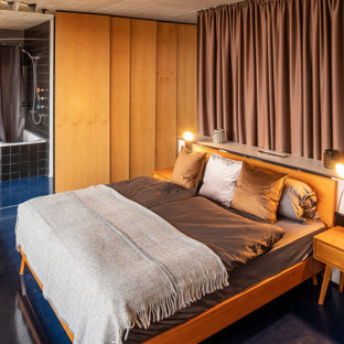 Großes Industrial Schlafzimmer im Loft-Style mit weißer Wandfarbe und blauem Boden in Berlin