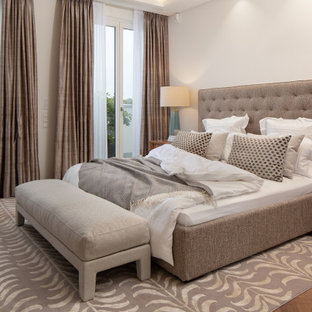 Großes Modernes Hauptschlafzimmer mit weißer Wandfarbe und braunem Boden in Berlin