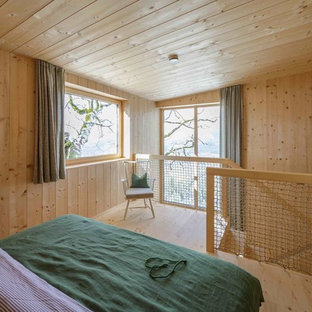 Ejemplo de dormitorio principal, nórdico, de tamaño medio, sin chimenea, con paredes marrones, suelo de madera clara y suelo marrón