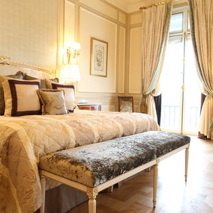 Esempio di una grande camera matrimoniale tropicale con pareti beige, pavimento in legno massello medio e nessun camino