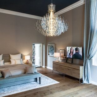 Diseño de dormitorio principal, contemporáneo, extra grande, con paredes beige, suelo de madera en tonos medios, estufa de leña, marco de chimenea de baldosas y/o azulejos y suelo marrón