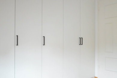Modernes Hauptschlafzimmer mit weißer Wandfarbe, braunem Holzboden und braunem Boden in München